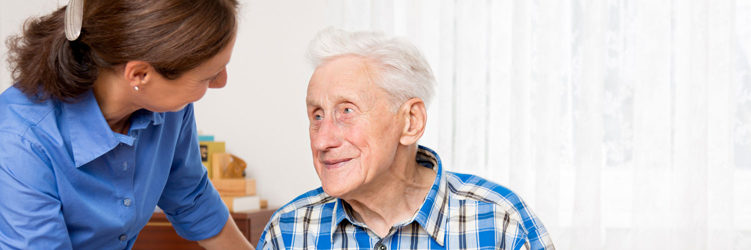 Caregiver talking with elderly man